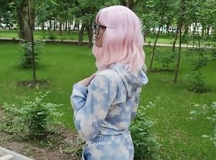Pink haired beauty walks in the park in a blue sky costume