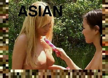 An asian and a blonde reveal their lesbian side outdoors