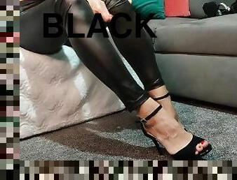 Trying on a black sexy high heels in faux leather leggigns
