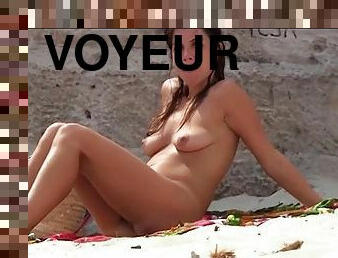 Voyeur films naked bodies on a nudist beach