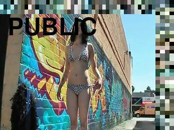 Cute chick models her bikini in the alley