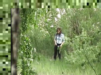 Slender babe is peeing in the forest