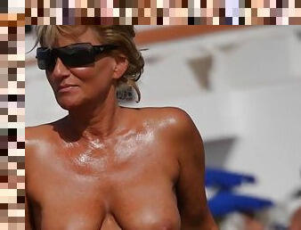 Nice tanned milf with big boobs at the beach
