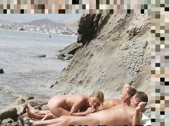 Skinny blonde cougar fucks on a nudist beach with two guys